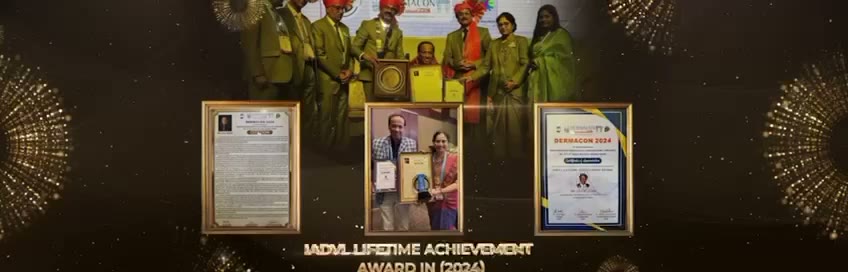 Group photo of award recipients in green blazers and orange turbans on stage, with three certificates displayed below, for the IADVL Lifetime Achievement Award.